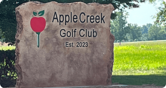 A sign for apple creek golf club