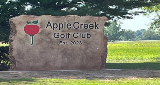 A sign for apple creek golf club