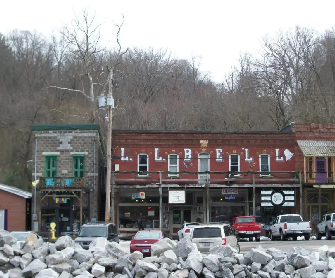 A street scene with cars parked in front of buildings.