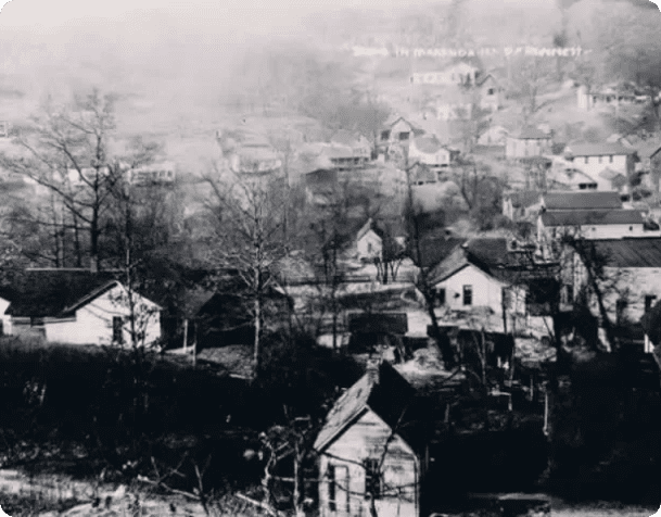 A black and white photo of houses in the distance.