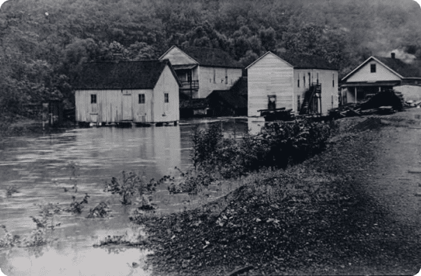 A black and white photo of houses on the water.