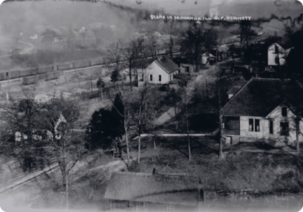 A black and white photo of houses on the side of a hill.