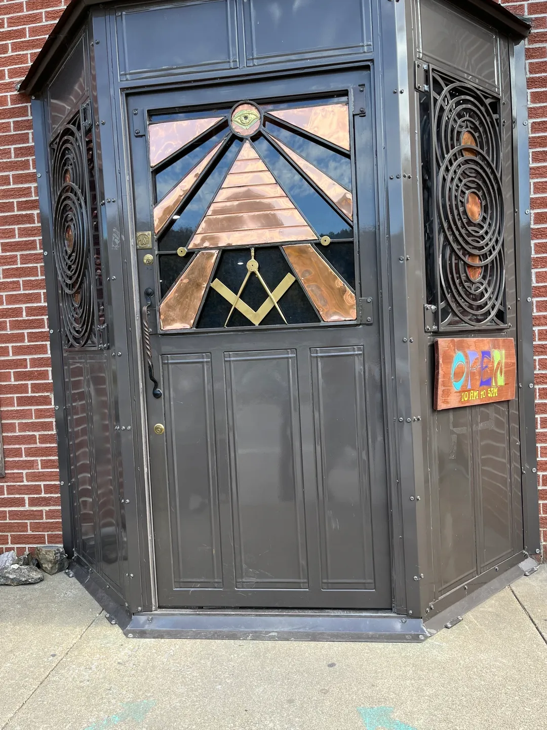 A black door with a stained glass window on the side.