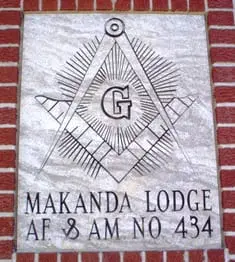 A sign on the side of a building with a masonic symbol.